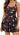 A woman models the Halcurt Women’s Ruffle Swimdress One Piece Swimsuit with Skirt – Floral by Halcurt, featuring a sleeveless design with adjustable shoulder straps, a fitted bodice, and a flared tiered skirt in a colorful floral print. Her long wavy hair is worn loose over one shoulder against a plain white background.