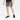 A person wearing a black T-shirt, All In Motion Men's Unlined Run Shorts 7" in gray, and black running shoes stands against a plain white background.