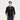 A man with short black hair stands sideways on a plain white background, wearing the Men's V-Neck Cardigan Sweater - Goodfellow & Co™ Black over a dark T-shirt and blue jeans, with his right hand in his pocket.