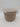 The Bullseye’s Playground™ Natural Woven Wicker Storage Basket - Medium with White Accent Handles showcases a stylish beige and brown pattern, complemented by a white fabric rim and a tag reading “STORAGE BASKET.” Set against a plain white background, this decorative basket is perfect for organizing any room.