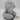 A mannequin displays the Bullseye’s Playground Hooded Travel Pillow, in light gray, featuring an attached hood for comfort and privacy during travel. This ergonomic neck support pillow by Bullseye’s Playground includes a small tag visible next to the pillow.