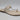 The Vince Camuto Lexiea Women’s Sandal in Panna Creme features a textured, snake print leather strap and a braided toe loop, shown as a single sandal on a white background.