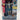 A white and blue Transformers EarthSpark Deluxe Class Terran Thrash Action Figure by Hasbro stands in a dynamic pose with gold accents, wielding a black weapon. One leg is equipped with a prominent wheel, highlighting its futuristic, mechanical design inspired by the robot-to-motorcycle transformation.