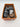 Pair of black, gray, and white patterned Rocket Dog Women’s Abel Plus Mules Black/Gray/White, Size 6 slip-on mules with two buckle straps, inside an open orange cardboard shoebox.