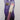 L.A. COLORS Beautifully Bewitched Magical pH Reactive Lip Oil in a sparkly purple tube with a white cap featuring gold star accents, displayed in purple-themed retail packaging.