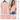 A woman with long, wavy hair is smiling and standing in a bright, minimally decorated room, wearing the Unbranded/Unknown Women’s Pink Short Sleeve V-Neck Blouse - Light Pink with two buttons, paired with blue jeans.