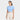 A woman wearing the JoyLab Women's Cropped Short Sleeve Shirt in light blue stands confidently against a plain light gray background, paired with high-waisted light beige pants.