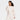 A woman in the Women's Fleece Cropped Crewneck Pullover Sweatshirt by JoyLab in cream stands against a plain background, smiling with one hand near her chin—an effortless addition to your athletic wardrobe.