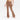 A person stands barefoot against a white background wearing JoyLab Women's High Rise Crossover Waistband Flare Leggings in brown, featuring a V-shaped waistband and athletic fit that hugs the thighs.