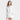 A woman wears the Women's Long Sleeve Collared Linen Button-Down Shirt by Universal Thread in white, relaxed fit and midweight, standing against a plain light background and smiling while looking slightly to the side.