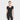 A woman wears the All In Motion Women's Seamless Rib Cropped Short Sleeve Shirt in black, a fitted pullover knit top, paired with matching high-waisted pants, standing against a plain white background with a gentle smile and relaxed arms.