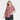 A woman with light brown hair wears an Ava & Viv Women’s Short Sleeve Scoop Neck Drapey T-Shirt in Light Red and dark cargo pants, standing confidently with one hand in her pocket against a plain white background.