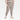 A person wearing All in Motion Women's Stretch Woven High-Rise Taper Pants in taupe stands with one hand in their pocket against a plain white background, paired with a matching crop top and beige sneakers.
