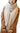 A person wearing a Wander Agio Women’s Warm Winter Infinity Blanket Scarf in beige, draped around their neck over a brown coat.