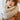 A person wearing a Wander Agio Women’s Warm Winter Infinity Blanket Scarf in beige, draped around their neck over a brown coat.
